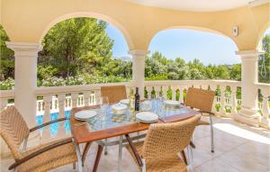 eine Veranda mit einem Tisch und Stühlen auf dem Balkon in der Unterkunft Amazing Home In Trullent in Benidoleig