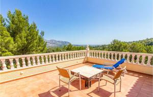 eine Terrasse mit Tisch und Stühlen auf einem Balkon in der Unterkunft Amazing Home In Trullent in Benidoleig