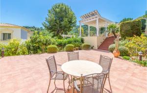 eine Terrasse mit einem Tisch, Stühlen und einem Pavillon in der Unterkunft Amazing Home In Trullent in Benidoleig