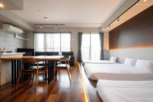 a hotel room with two beds and a table at Minn Chitose in Chitose