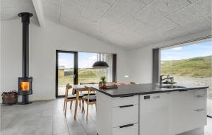 a kitchen with white cabinets and a table with chairs at Holiday Home Hvide Sande 25 in Bjerregård