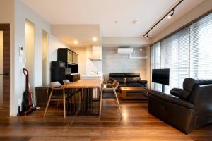 a living room with a table and a couch at Minn Chitose in Chitose