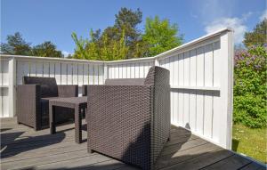 eine Holzterrasse mit 2 Stühlen und einem Tisch in der Unterkunft Three-Bedroom Holiday Home In Ebeltoft in Ebeltoft + 24 Fotos