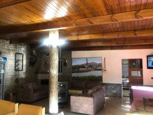 a living room with couches and a tree in a room at Hotel Xhej in Rubik