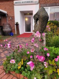 AhlefeldRoom and kitchen im Katerberg的一个种有粉色花朵的花坛和一座雕像