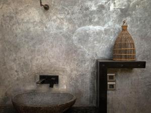 a bathroom with a sink and a bird cage on the wall at Iron Rose Villa with garden & pool Kuta Lombok in Kuta Lombok +29 photos