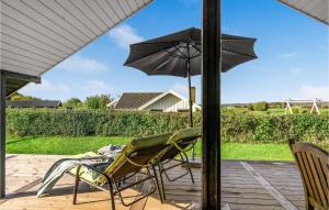 a couple of chairs and an umbrella on a patio at Holiday Home Teglbakken Egernsund I in Egernsund +19 photos