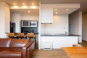 a living room with a couch and a kitchen at Minn Chitose in Chitose +4 photos