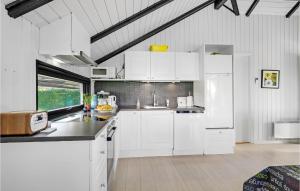 a white kitchen with white cabinets and a sink at Holiday Home Teglbakken Egernsund I in Egernsund