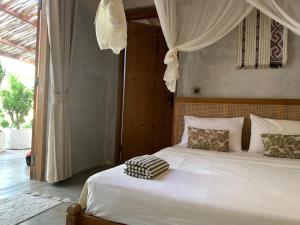 a bedroom with a white bed with a canopy at Iron Rose Villa with garden & pool Kuta Lombok in Kuta Lombok