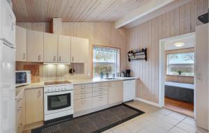 a kitchen with white cabinets and a sink and a window at Holiday Home Egernsund With Patio 319 in Egernsund