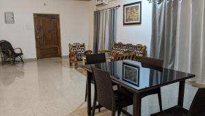 a dining room with a black table and chairs at La Vaiencia Villas in Morjim