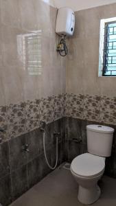 a bathroom with a toilet and a shower at La Vaiencia Villas in Morjim