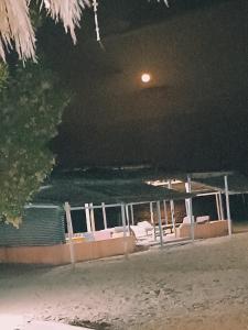 un barco sentado en la playa por la noche en Antika beach camp, en Nuweiba