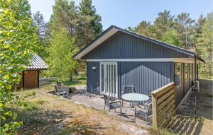 un cobertizo negro grande con mesa y sillas en Holiday Home Nexo L, en Spidsegård