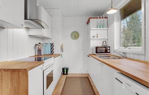 a kitchen with white cabinets and a wooden counter top at Three-Bedroom Holiday Home In Sydals in Skovbyballe