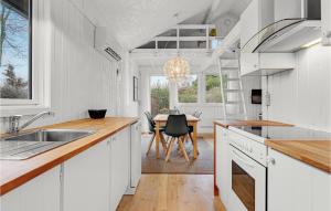 a kitchen with white cabinets and a dining table at Three-Bedroom Holiday Home In Sydals in Skovbyballe