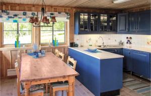a kitchen with blue cabinets and a wooden table at Holiday Home Vikeså Stavtjørn Iii in Hovland
