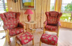 a living room with two chairs and a lamp at Holiday Home Vikeså Stavtjørn Iii in Hovland