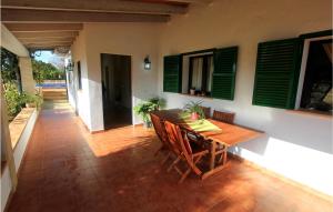 a dining room with a table and some green shutters at 2 Bedroom Gorgeous Home In Algaida in Algaida