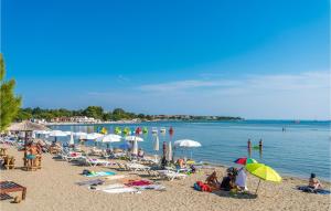 Grupa ludzi na plaży z parasolami w obiekcie Holiday Home Medulin 33 w Medulinie