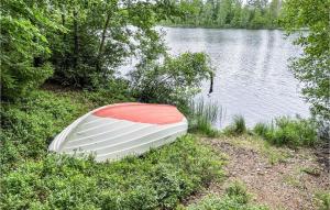 un barco sentado a un lado de un lago en Two-Bedroom Holiday Home In Brakne Hoby, en Smedamåla