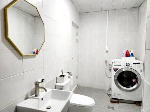 a bathroom with a washing machine and a sink at Breathe Hanok Village Nambu Market in Jeonju