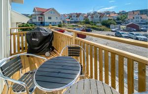a table and chairs on a balcony with a view of a parking lot at Cozy Apartment In Rönnäng With Kitchen in Rönnäng