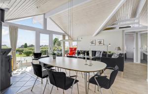 a dining room and living room with a table and chairs at Holiday Home Havremarken Sjølund Ii in Hejls