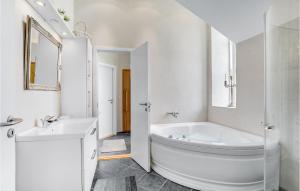 a white bathroom with a tub and a sink at Holiday Home Havremarken Sjølund Ii in Hejls +20 photos