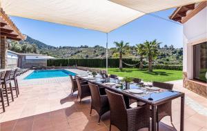 an outdoor dining area with a table and chairs and a pool at 4 Bedroom Nice Home In Cómpeta in Acebuchal