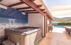 a hot tub on a patio next to a swimming pool at 4 Bedroom Nice Home In Cómpeta in Acebuchal +40 photos