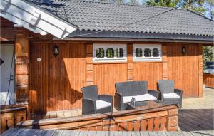eine Terrasse mit vier Stühlen auf einem Holzzaun in der Unterkunft Four-Bedroom Holiday Home In Kornsjo in Kornsjø