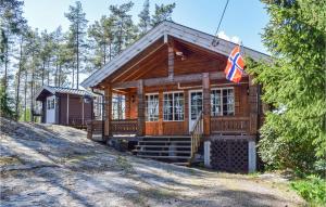 eine Blockhütte mit einer Flagge davor in der Unterkunft Four-Bedroom Holiday Home In Kornsjo in Kornsjø + 9 Fotos