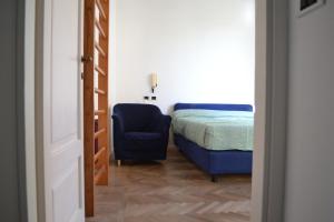 a bedroom with a bed and a blue chair at La Liberty in Marciana Marina