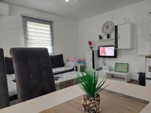 a living room with a table and a couch and a television at Vikendica SUNCE in Banja Luka +6 photos