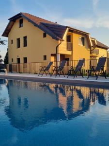 a house with chairs next to a swimming pool at Vila K2 in Vrdnik