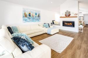 a living room with a white couch and a fireplace at Golden Beach Ultimate Family Getaway - Pool & Spa in Golden Beach +42 photos