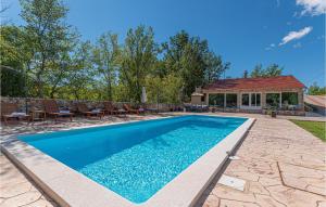 a swimming pool with chairs and a house at Gorgeous Home In Knin With Kitchen in Razvala