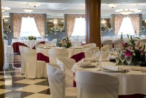 a banquet hall with white tables and chairs at Hotel Alhama in Cintruénigo