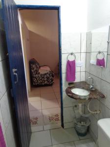 a small bathroom with a sink and a mirror at Casa Mobiliada Galinhos in Galinhos