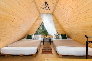 VenoSea Tsikhisdziri Seaside Cottage في تسيكهيسدزيري: غرفة بثلاث أسرة في علية خشبية