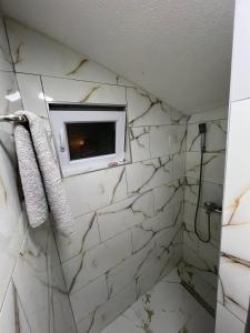 a bathroom with a white marble wall at Apartman Royal sa GARAŽOM i KLIMOM in Visoko +26 photos