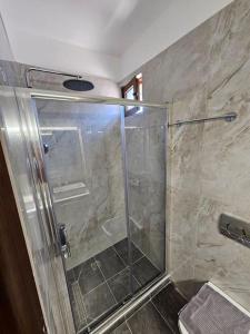 eine Dusche mit Glastür im Badezimmer in der Unterkunft Sani Pinecone Villa 3 in Sani Beach
