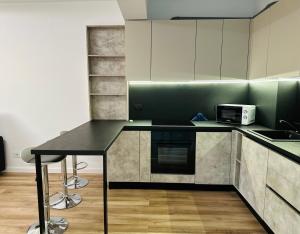 a kitchen with a black counter top and a microwave at Zenit Apartment Oradea in Oradea