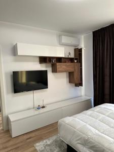 a bedroom with a bed and a tv on the wall at Zenit Apartment Oradea in Oradea