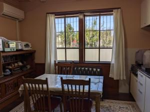 a kitchen with a table and chairs and a window at 民泊サライ七城 in Kikuchi