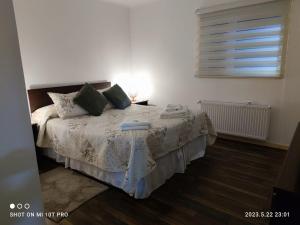 a bedroom with a bed and a window at Cabañas 2 olimai in Puerto Natales +5 photos