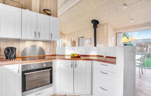 a kitchen with white cabinets and a counter top at Holiday Home Sandleddet Højby Ii in Lumsås +23 photos