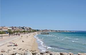 a beach with people laying on the sand and the water at Es Molinar in Palma de Mallorca